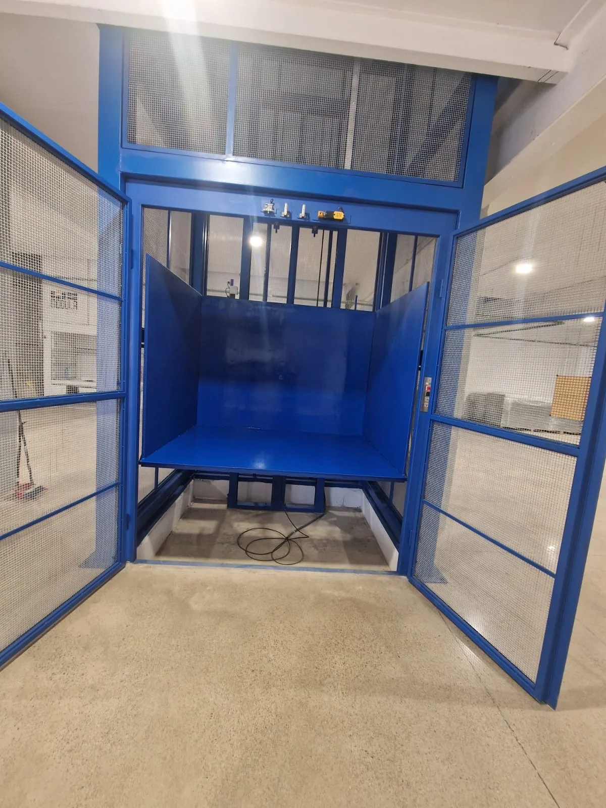 Montacargas con las puertas abiertas y la plataforma a ras de suelo