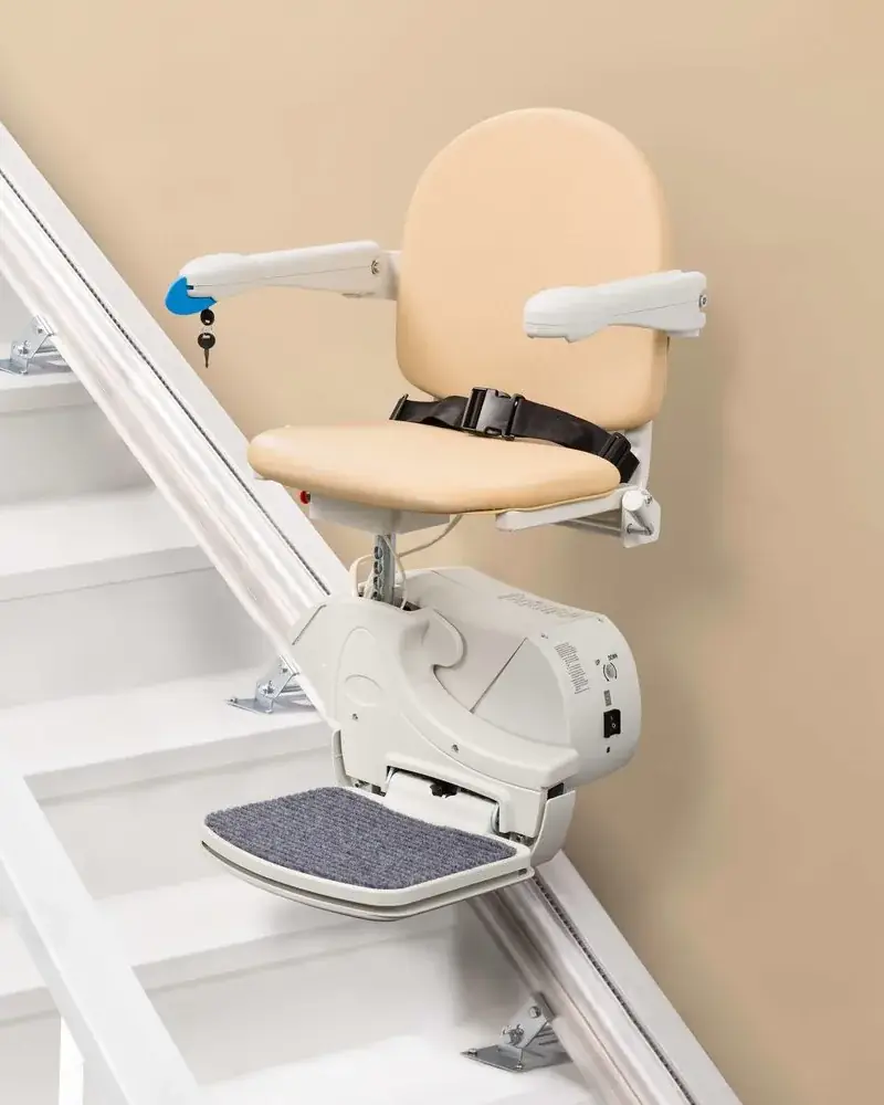 Silla salvaescaleras con asiento tapizado y reposapiés plegable en una escalera recta