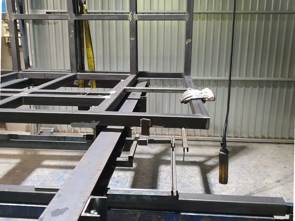 Bastidor metálico sobre caballetes en el taller, con una herramienta colgada de la estructura