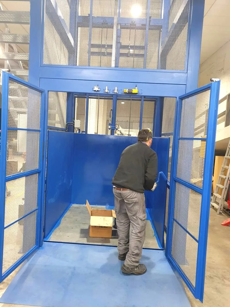 Operario cargando mercancía en montacargas industrial en Barcelona